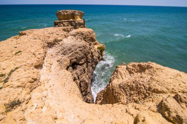 Yürüyen adam ve plajda kayalar ile Atlantik Okyanusu ve kayalıklarla, algarve Portekiz manzarasının keyfini çıkarın. Yaz meslek kavramı