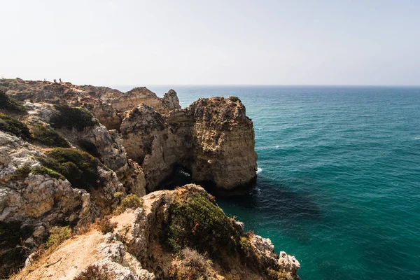 Güzel Atlantik Okyanusu görünümü ufuk kumlu plaj kayalar ve gündoğumu algarve dalgaları