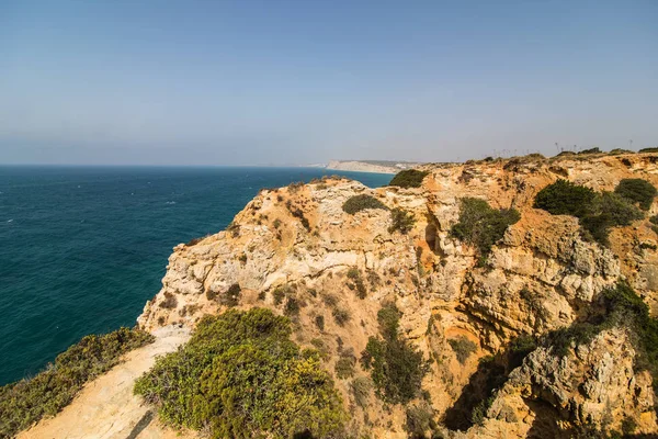 Güzel Atlantik Okyanusu görünümü ufuk kumlu plaj kayalar ve gündoğumu algarve dalgaları