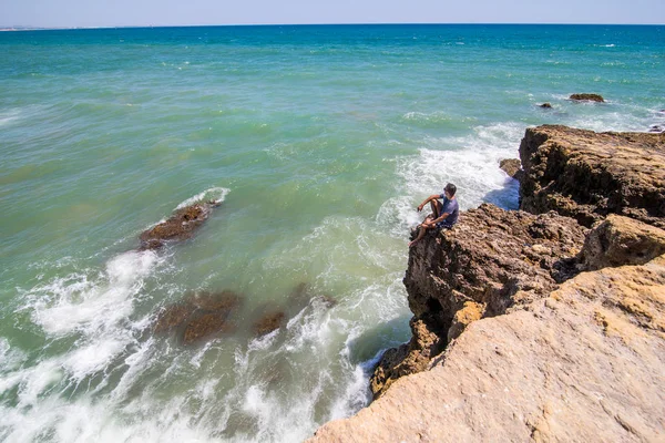 Cesur adam zevk saatler okyanusun üstünde tepe-in cliff, rock güzel rock Beach sonuna. Yaz meslek kavramı
