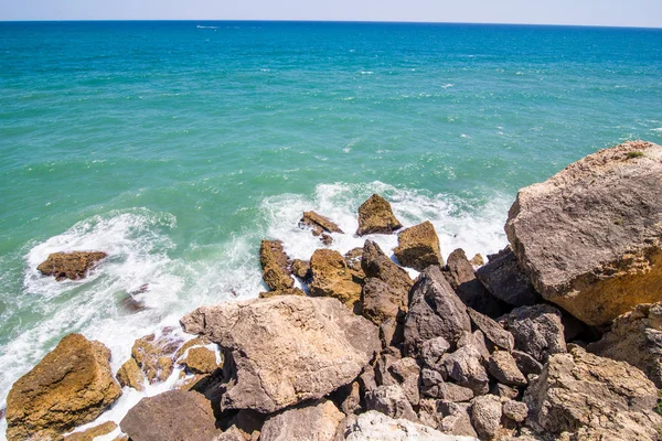 Dalgalar Atlantik Okyanusu Portekiz kıyısında, taşlarda kır. Yaz meslek kavramı