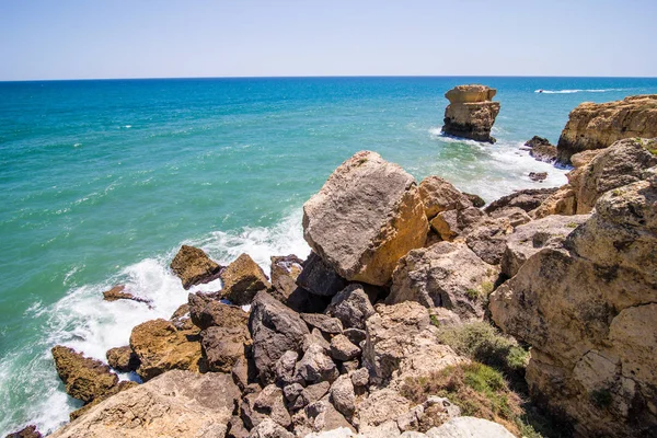 Dalgalar Atlantik Okyanusu Portekiz kıyısında, taşlarda kır. Yaz meslek kavramı