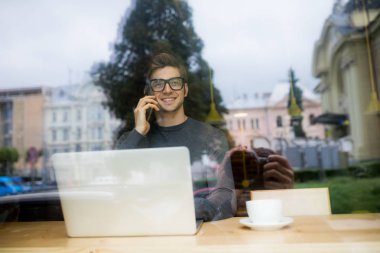 Tablet bilgisayar kullanarak ve kahve içme genç adam