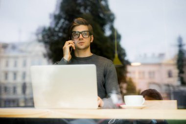 Tablet bilgisayar kullanarak ve kahve içme genç adam