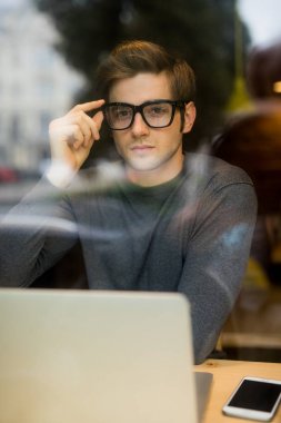 Tablet bilgisayar kafe dükkanda kullanan genç adam