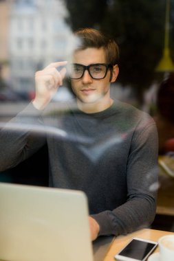 Tablet bilgisayar kafe dükkanda kullanan genç adam