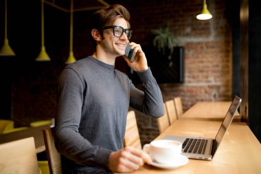 Göz gözlük yakışıklı freelancer konuşmak smartphone laptop süre