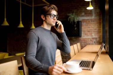 Göz gözlük yakışıklı freelancer konuşmak smartphone laptop süre