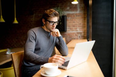 Genç başarılı bir iş adamı, café Durin'in eser otururken bir dizüstü bilgisayarda çalışma