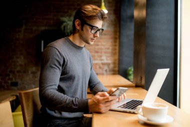 Hatta bir kafede bir dizüstü bilgisayar ile çalışan serbest adam