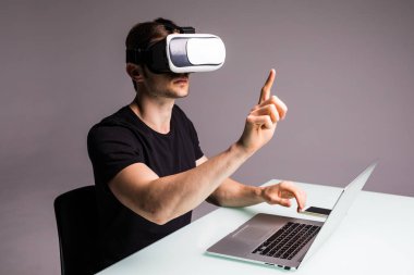 Sanal gerçeklik giyen genç adam gözlük ve video oyun oynarken parmak ile işaret