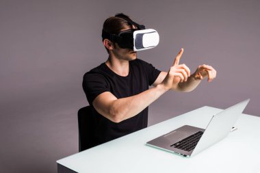 Sanal gerçeklik giyen genç adam gözlük ve video oyun oynarken parmak ile işaret