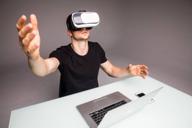 Genç yakışıklı cyber kafede oturan ve sanal gerçeklik kulaklık veya gözlük kullanan adam. Oyun kavramı