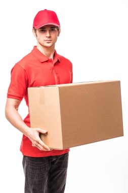 Bir karton kutu tutarak ve beyaz arka plan üzerinde dururken gülümseyen neşeli teslimat adam mutlu genç kurye