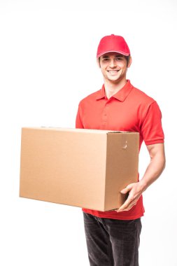 Bir karton kutu tutarak ve beyaz arka plan üzerinde dururken gülümseyen neşeli teslimat adam mutlu genç kurye