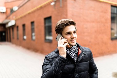 Tuğla bina sokakta telefonla konuşan genç yakışıklı adam 