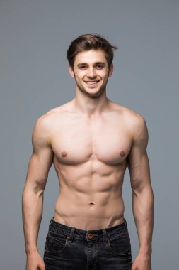 Yakışıklı delikanlı ile çıplak gövde kameraya gri arka plan üzerinde seyir 