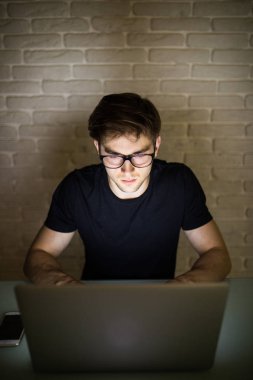 Gözlük, Hacker dizüstü bilgisayar kullanarak gece adam ofiste çalışan genç işadamı closeup görünümünü sakallı