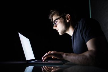 Dizüstü bilgisayar evde kapalı gece beyaz dizüstü bilgisayar ekranına bakarak kullanan adam genç konsantre