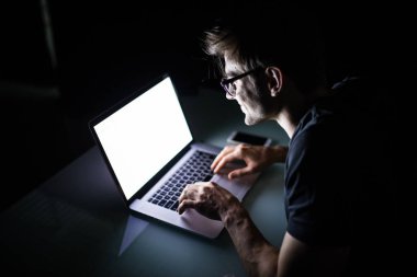 Dizüstü bilgisayar evde kapalı gece beyaz dizüstü bilgisayar ekranına bakarak kullanan adam genç konsantre