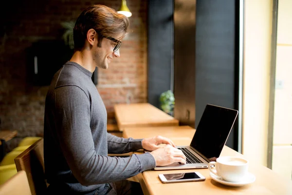 英俊的男人，在一家咖啡馆咖啡与笔记本电脑 — 图库照片