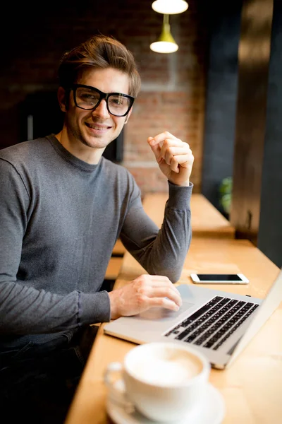 Diz üstü ofis video izlerken kahve içme gözlük yakışıklı işçi 