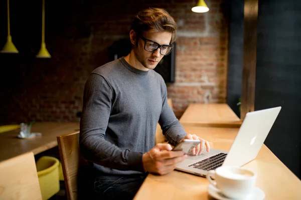 Hombre independiente trabajando en línea con un portátil en una cafetería — Foto de Stock