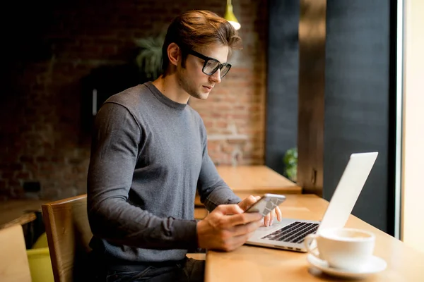 Hombre independiente trabajando en línea con un portátil en una cafetería — Foto de Stock