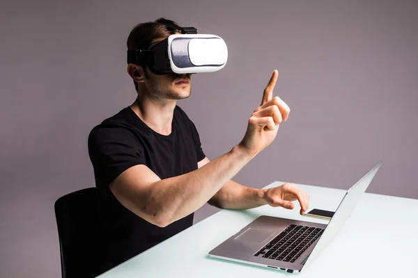 Ung man klädd i virtuell verklighet skyddsglasögon och spelar videospel pekade med fingret — Stockfoto