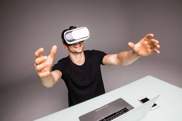 Ung man klädd i virtuell verklighet glasögon och spela videospel selektivt fokus på händerna. Gaming concept — Stockfoto