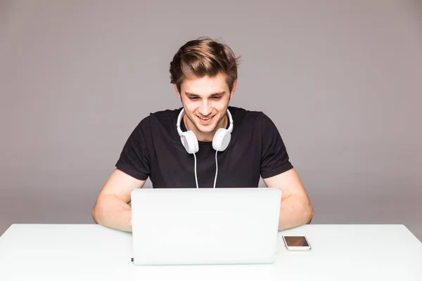 Homem feliz trabalhando na frente do laptop na mesa de escritório — Fotografia de Stock