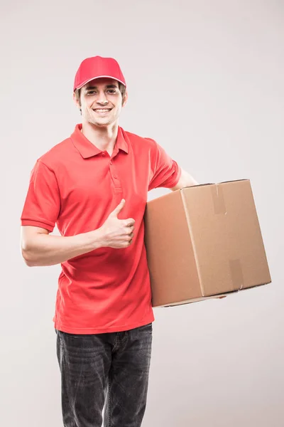 Szállítási ember egységes, és remek piros doboz elszigetelt fehér kezében — Stock Fotó