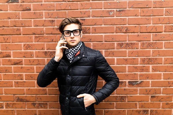 Retrato de homem falando no telefone sobre tijolo parede fundo — Fotografia de Stock