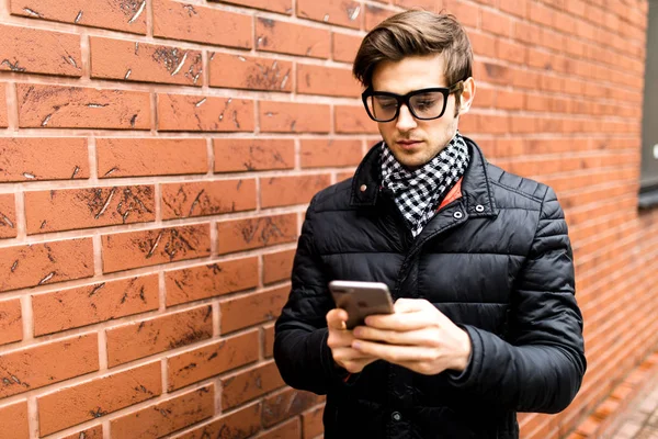 Metin iletisi yan görünüm yakışıklı genç adam cep telefonu tutan akıllı rahat kıyafet içinde yazarak