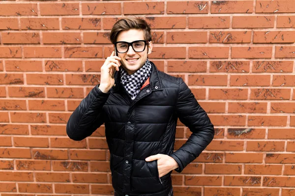 Retrato de homem falando no telefone sobre tijolo parede fundo — Fotografia de Stock