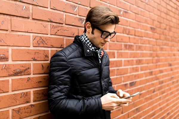 Metin iletisi yan görünüm yakışıklı genç adam cep telefonu tutan akıllı rahat kıyafet içinde yazarak