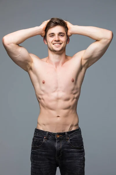 Jovem muito bonito homem com músculo torso no fundo cinza — Fotografia de Stock