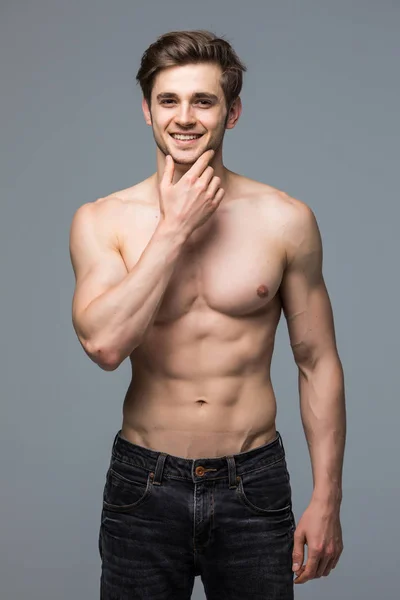 Çene genç adam gri bir arka plan üzerinde sağlıklı kas eller