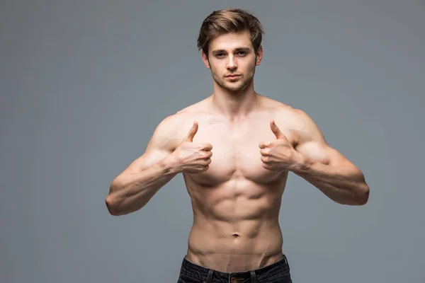 Modèle de fitness masculin avec corps musclé sexy portrait beau jeune homme chaud avec des pouces athlétiques en forme vers le haut — Photo