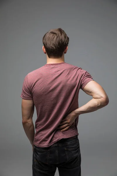 Hombre con dolor en el cuello sobre fondo gris — Foto de Stock