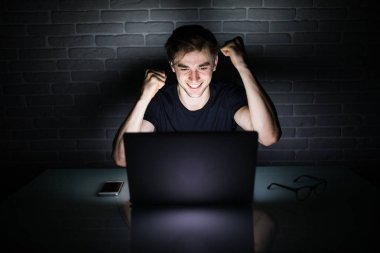 Yatakta muzaffer bir hareketi ile neşeli adam adam bilgisayar başında zafer hareketlerle heyecanlı