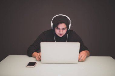 Tablo üzerinde bir dizüstü bilgisayarda çalışan adam Hacker 