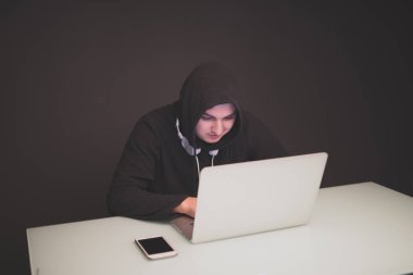 Hacker bilgileri çalmak karanlıkta bir masada oturma
