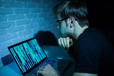 Dizüstü bilgisayar saldırı ağ yazılımı gece çalışan genç adam hacker 