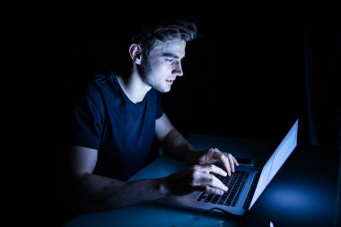 Teknoloji Internet iletişim ve insan kavramı genç adamla dizüstü bilgisayar gece zamanında