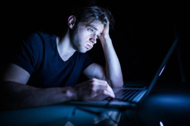 Gece önünde in laptop otururken hayal kırıklığına uğramış genç adam duygu yorgun 