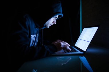 Adam hacker karanlık oda kesmek içinde laptop üzerinde ağ gece çalışıyor