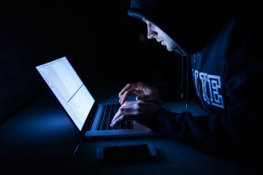 Adam hacker karanlık oda kesmek içinde laptop üzerinde ağ gece çalışıyor