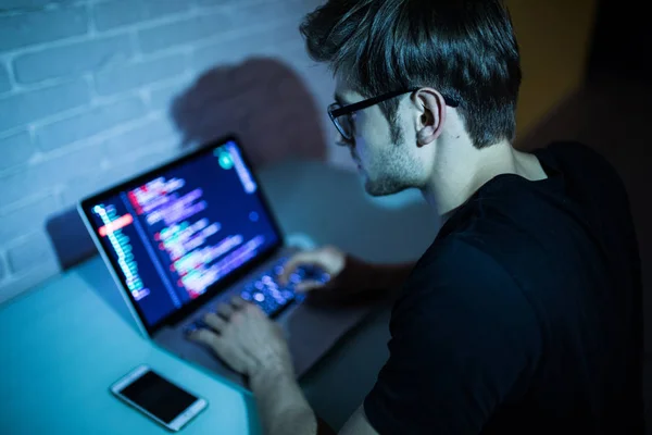 Портрет хакера с ноутбуком на темном фоне ночью — стоковое фото