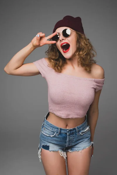 Närbild studio skott av vacker hipster tonårsflicka med mössa Skäggtorsk gestikulerande fred fyrkantig — Stockfoto